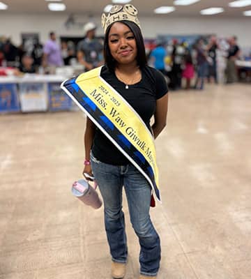 A student wearing a crown and royalty sash