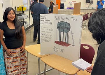 students looking at display boards set throughout a room