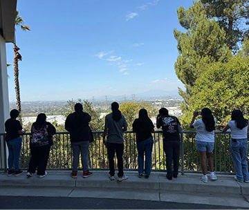Students looking across an overlook of a city