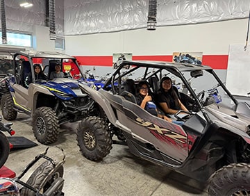 Students sitting in ATVs
