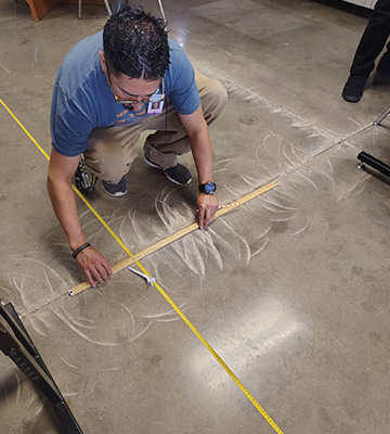 A person measuring marks on the floor
