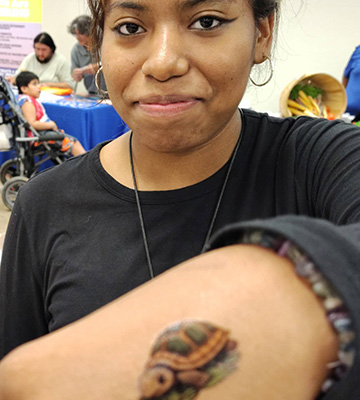 A students showing a tattoo of a turtle on the back of their hand