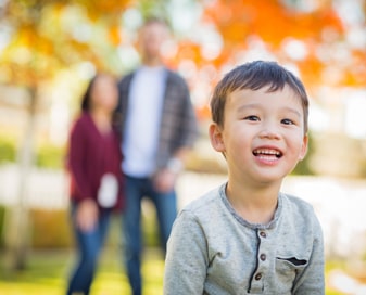 Boy with parents in background
