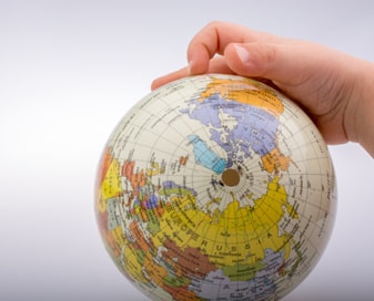 Child's hand on a globe