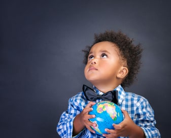 Little boy in a bowtie holding a globe