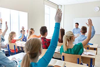 Students raising their hands in class