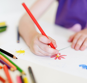Student drawing flowers with pencils on paper