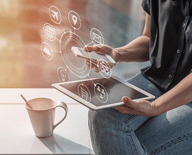 Femail outside using a mobile phone and a table with a cup of coffee on the table