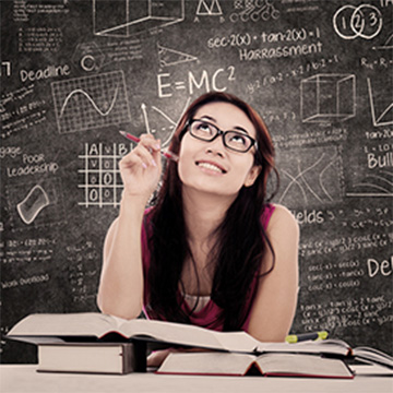 Female student thinking with open books in front of her and a chalkboard full of formulas and shapes behind her