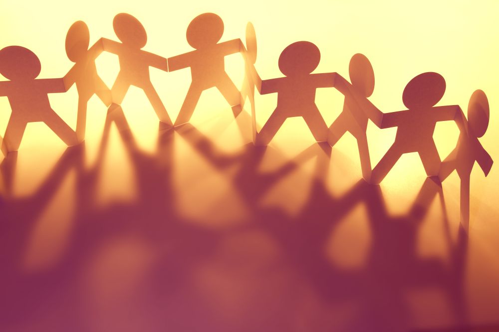 paper cutouts of people holding hands