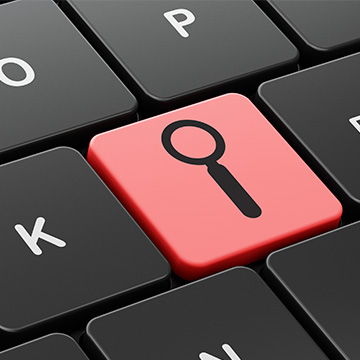 section of a keyboard with a key that has a magnifying glass