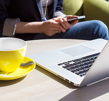 Parent checking her mobile while in a coffee shop