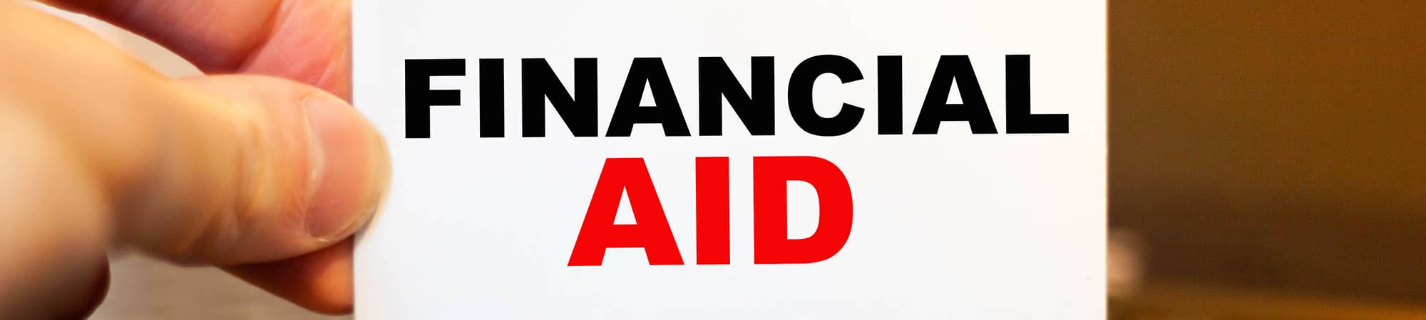 A hand holding a card the reads Financial Aid