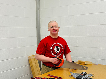 Student sawing a piece of wood