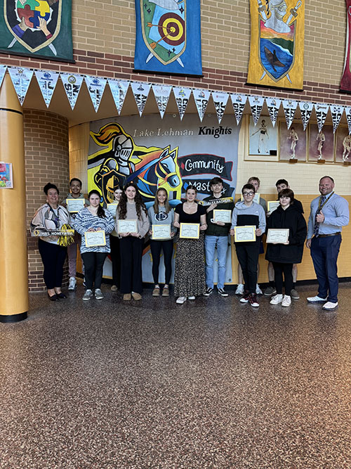 Principal with students of the month inside the school hallway