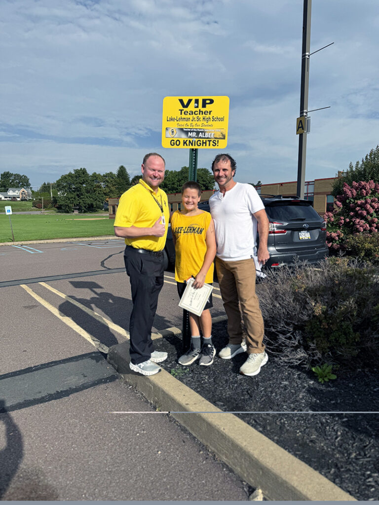 Teacher of the Month for September 2026 with student and principal