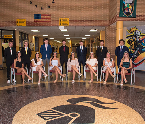 Junior Senior HS Homecoming court sitting in chairs