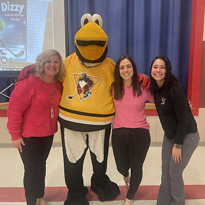staff members smiling with the mascot