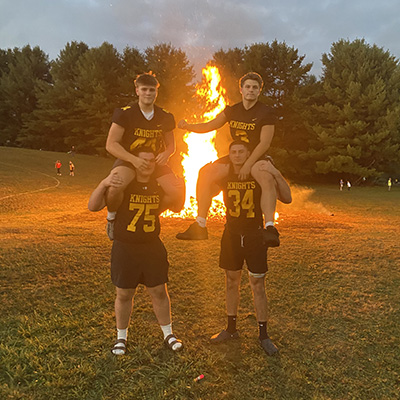 football players in front of a bonfire