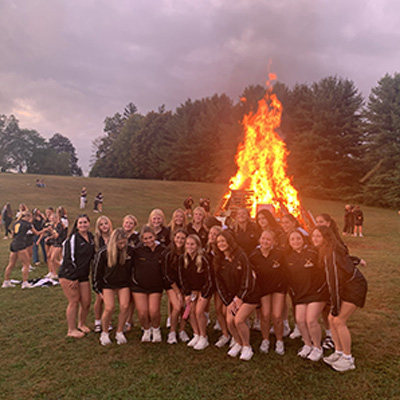 cheerleaders in front of a bonfire