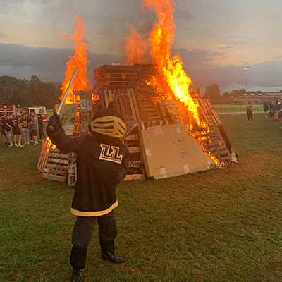 Mascot in front of bonfire