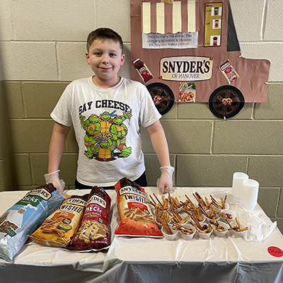 boy in front of table full of pretzels