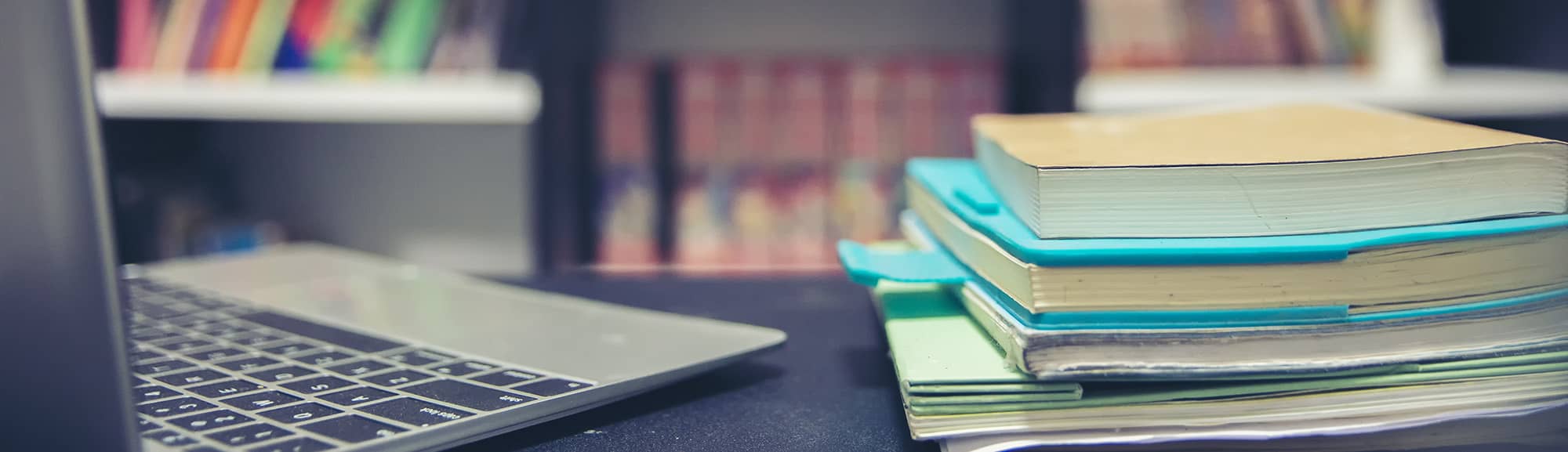 book and laptop on table in a library