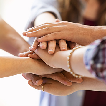 people in a circle uniting their hands