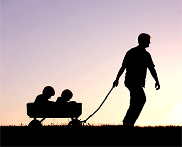 An Adult pulling kids in a wagon