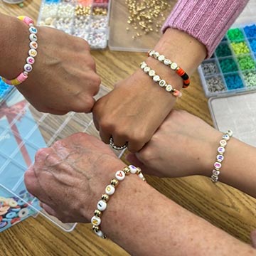 Students and teachers with bracelets putting their fists together