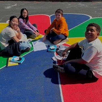 Students sitting and working on a project outside Students sitting and working on a project outside