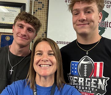 Teacher smiling with two students