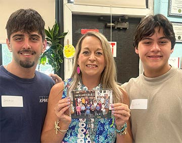 Teacher with two alumni from her old class