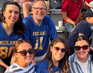 Parents sitting on the bleachers and smiling Parents sitting on the bleachers and smiling
