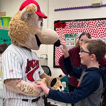 Student shaking hands with mascot