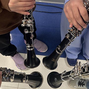 Students pointing clarinets towards each other in a circle