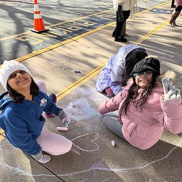 Students drawing with chalk on the floor outside Students drawing with chalk on the floor outside
