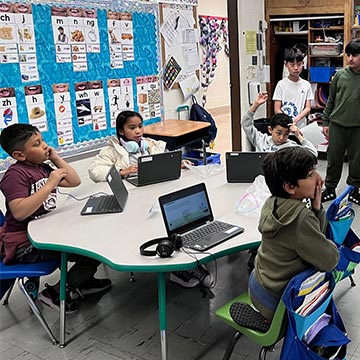 Students on laptops in class Students on laptops in class