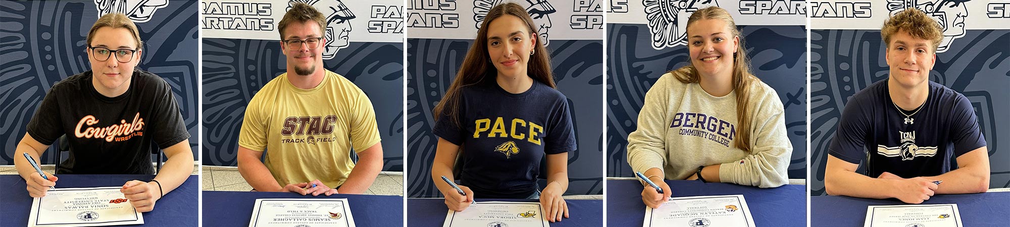 Students sitting at a table signing a paper
