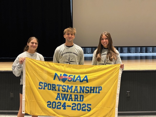 Three happy athletes holding up a sportsmanship banner