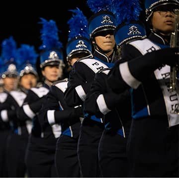 Cup of coffee, notepad, and red apple on a desk with a keyboard