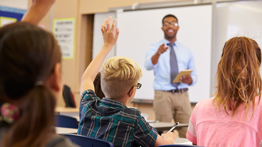 Teacher pointing to students with raised hands