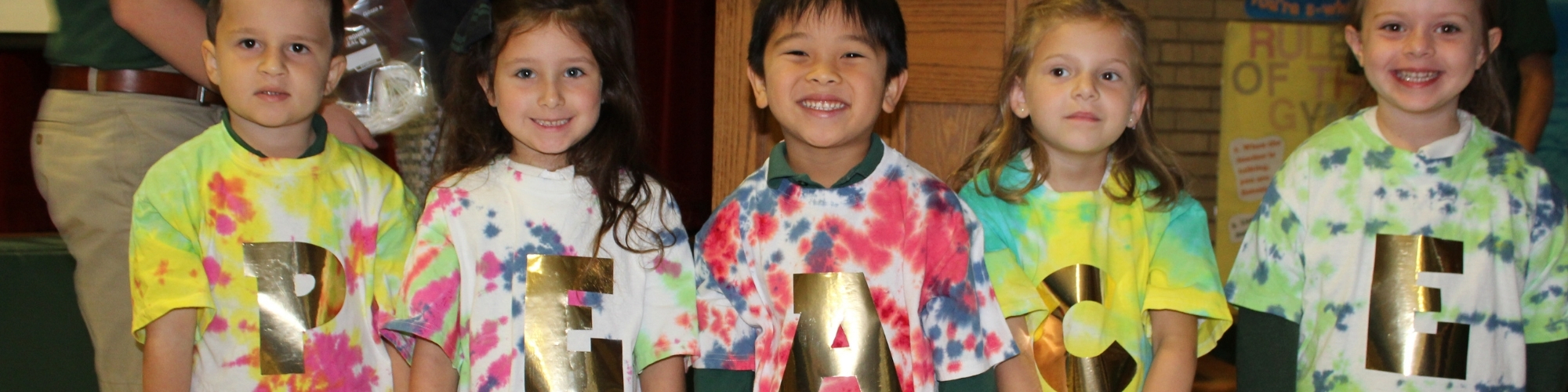 students wearing shirts with letters on them reading Peace.