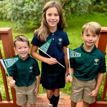 Students wearing uniforms and holding grade pendants