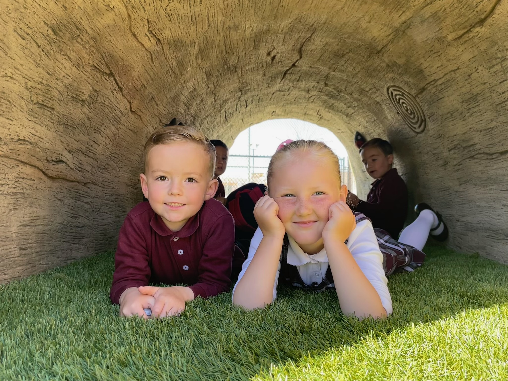 students inside a log tunnel