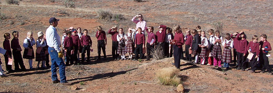 Group of students and two adults outside