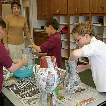 Teacher helping students with a craft project
