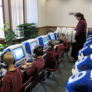A teacher watching students working on computers
