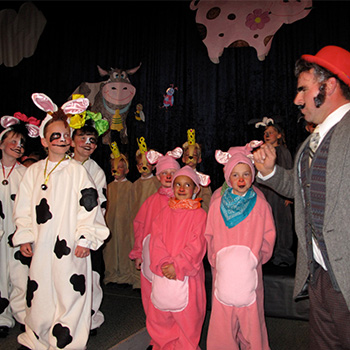 An adult and students in costume