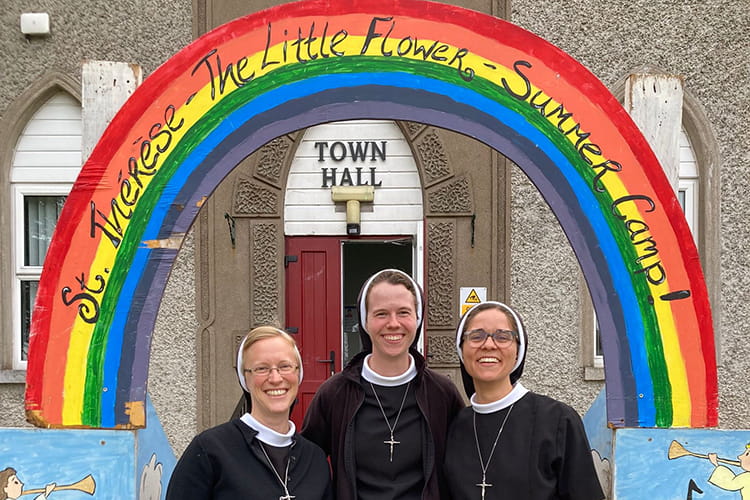three sisters helping with a children's camp